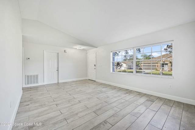 unfurnished room with light hardwood / wood-style floors and vaulted ceiling