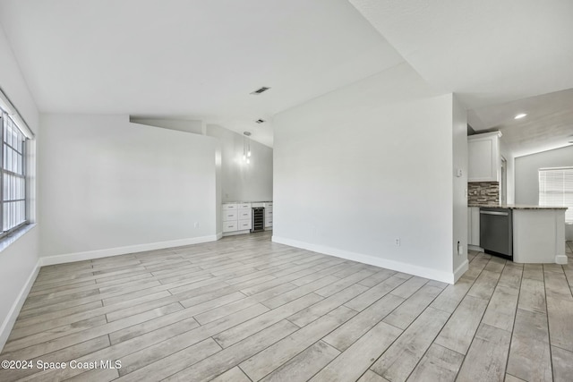 unfurnished living room with light hardwood / wood-style floors and vaulted ceiling