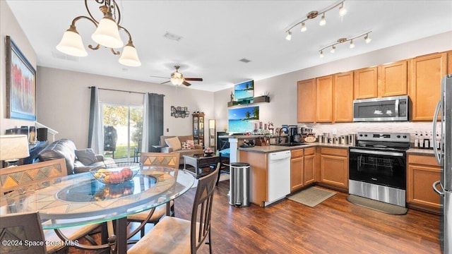 kitchen featuring sink, hanging light fixtures, dark hardwood / wood-style floors, kitchen peninsula, and stainless steel appliances