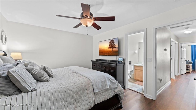 bedroom with ensuite bath, ceiling fan, and dark wood-type flooring