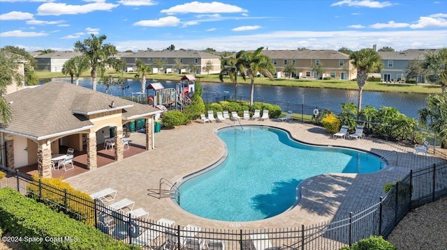 view of swimming pool with a water view and a patio area