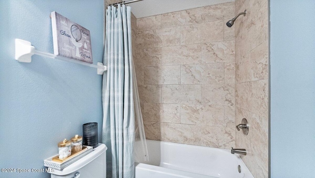 bathroom with shower / tub combo and toilet