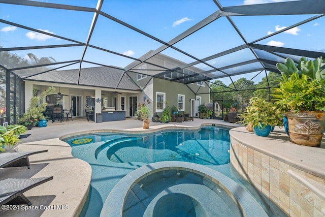 view of pool with glass enclosure, an in ground hot tub, ceiling fan, and a patio