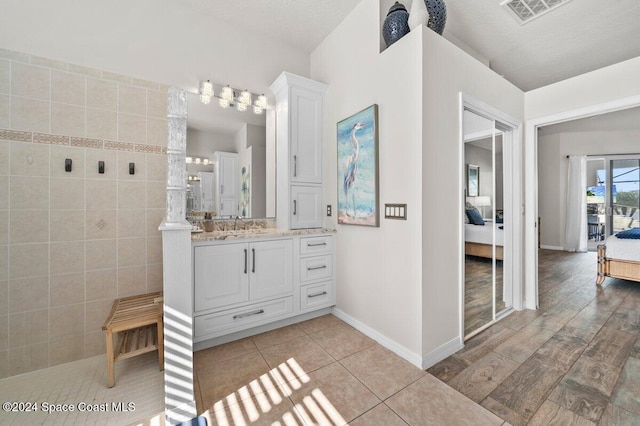 bathroom with vanity, wood-type flooring, a textured ceiling, and walk in shower