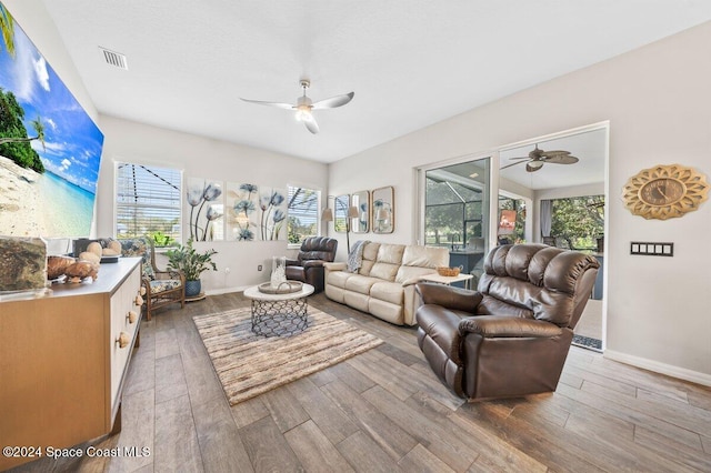 living room with ceiling fan, a healthy amount of sunlight, and light wood-type flooring