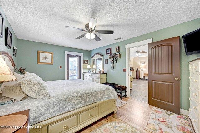 bedroom featuring a textured ceiling, light hardwood / wood-style flooring, and ceiling fan