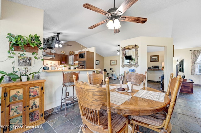 dining area featuring ceiling fan, a textured ceiling, and vaulted ceiling