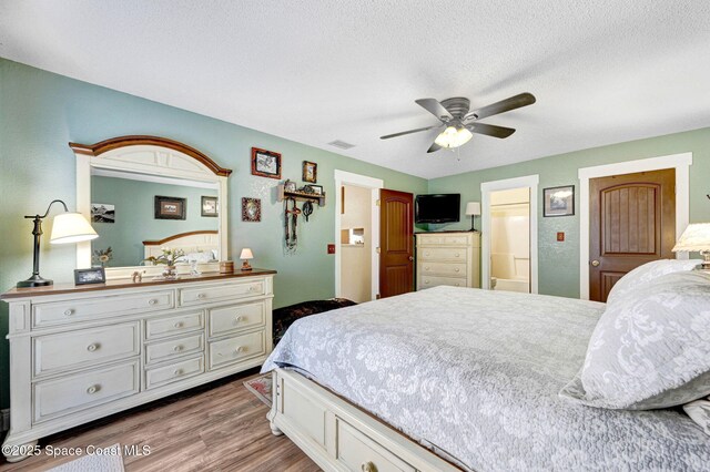 bedroom featuring ceiling fan, a textured ceiling, and hardwood / wood-style flooring