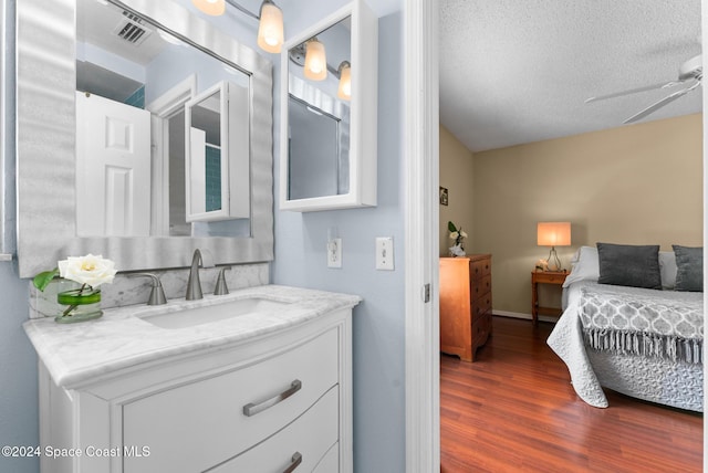 bathroom featuring ceiling fan, wood-type flooring, a textured ceiling, and vanity