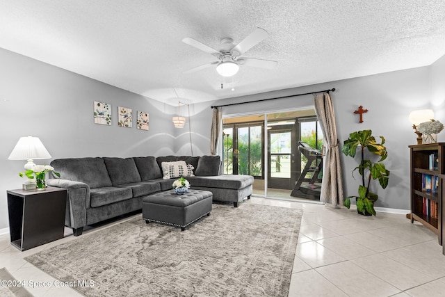 living room with a textured ceiling, ceiling fan, and light tile patterned flooring