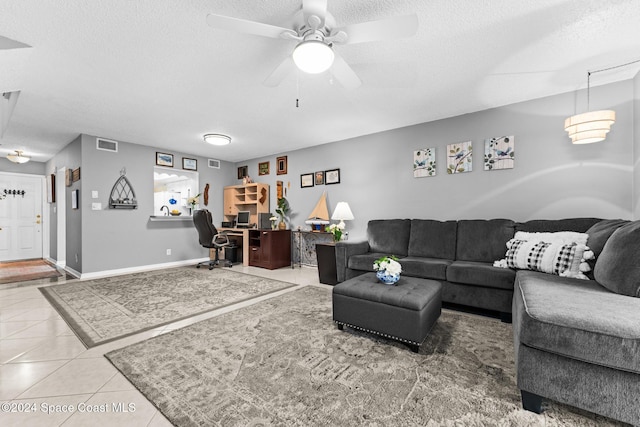 living room featuring a textured ceiling, tile patterned floors, and ceiling fan