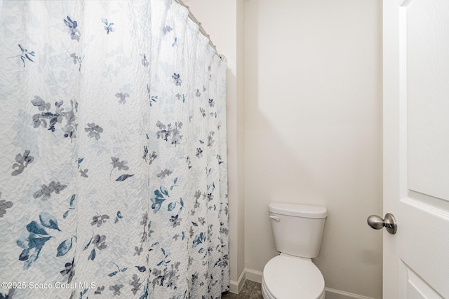 bathroom featuring walk in shower and toilet