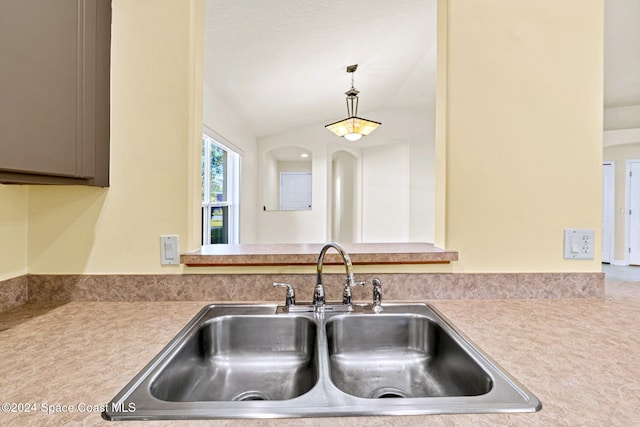 kitchen featuring sink, hanging light fixtures, and vaulted ceiling