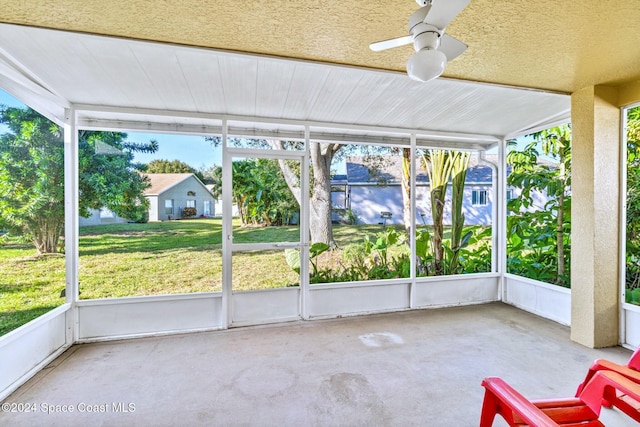 unfurnished sunroom with ceiling fan