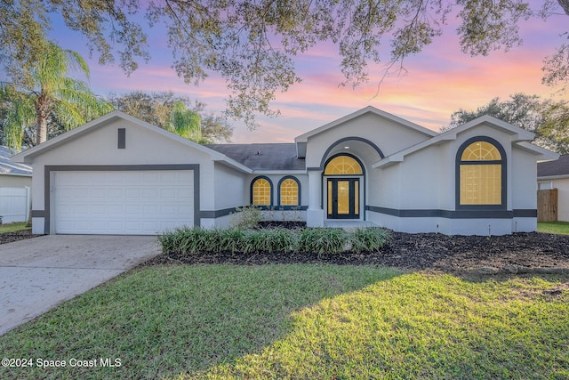 single story home with a lawn and a garage