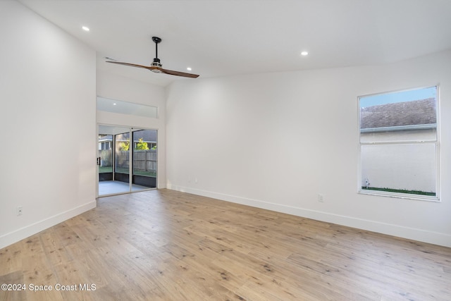 spare room with ceiling fan, light hardwood / wood-style floors, and vaulted ceiling