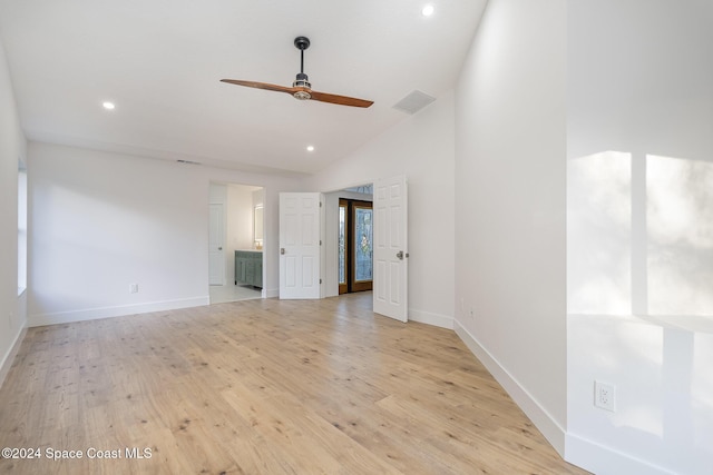 spare room featuring light hardwood / wood-style floors, vaulted ceiling, and ceiling fan