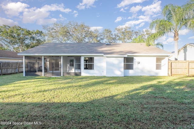 back of property featuring a sunroom and a yard