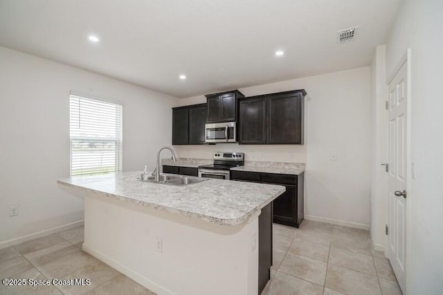 kitchen featuring sink, appliances with stainless steel finishes, a kitchen island with sink, and light tile patterned flooring