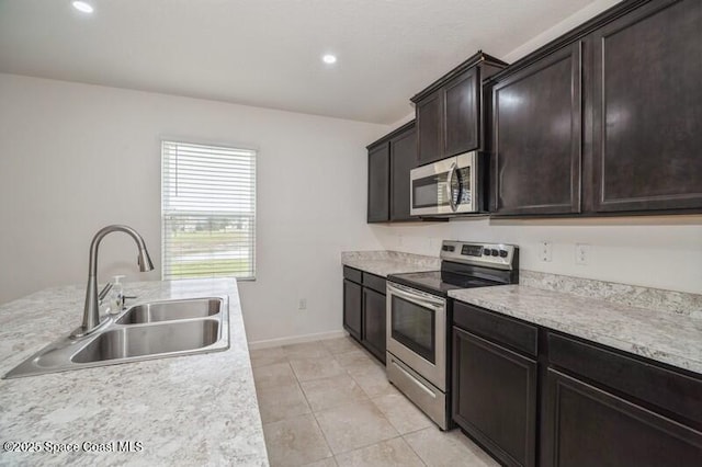 kitchen with sink, dark brown cabinetry, stainless steel appliances, and light tile patterned flooring