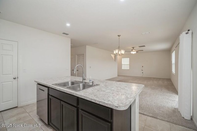 kitchen with light colored carpet, dishwasher, a center island with sink, sink, and hanging light fixtures