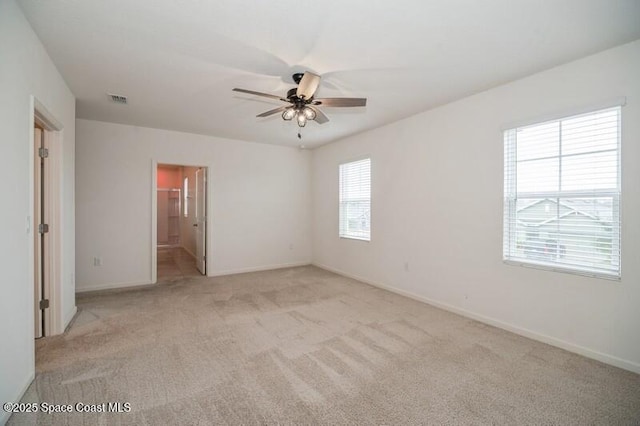 carpeted spare room with ceiling fan