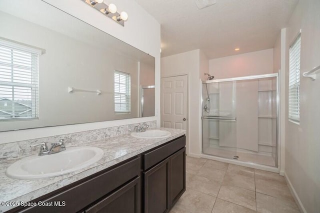 bathroom with an enclosed shower, vanity, and tile patterned flooring