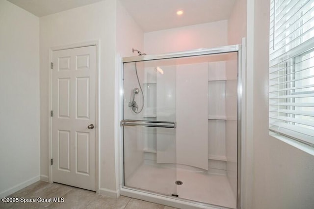 bathroom with an enclosed shower and tile patterned flooring