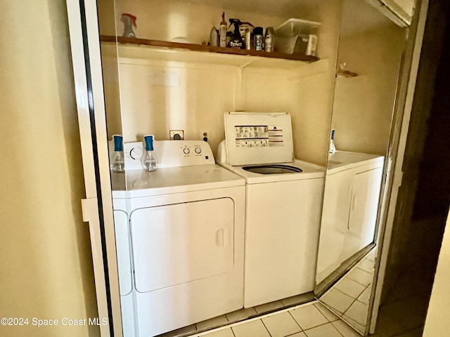 clothes washing area with light tile patterned flooring and washing machine and dryer