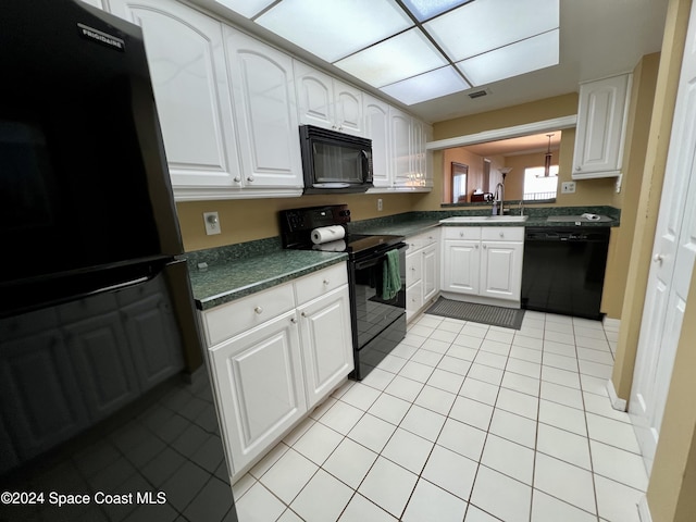 kitchen with light tile patterned flooring, sink, white cabinetry, and black appliances