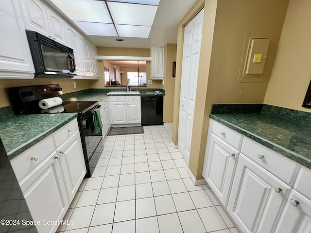 kitchen featuring sink, light tile patterned floors, electric panel, white cabinets, and black appliances