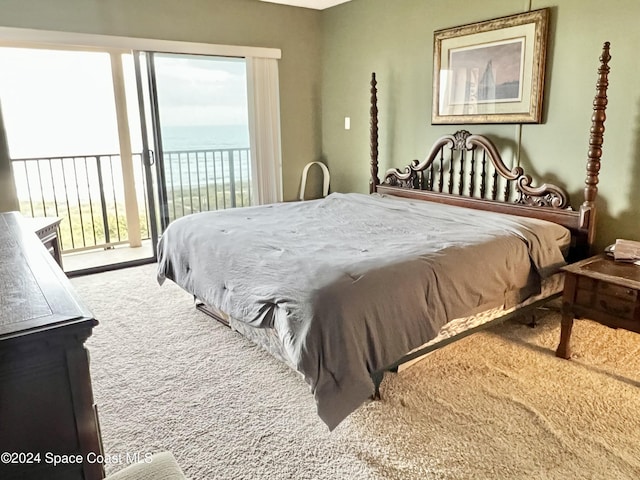 bedroom with access to exterior, a water view, and carpet