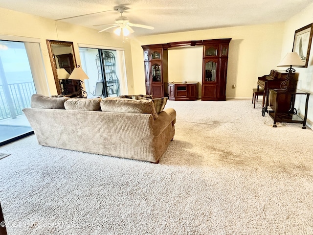 living room featuring carpet, a textured ceiling, and ceiling fan