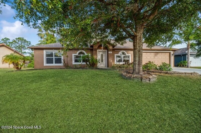 ranch-style house featuring a garage and a front lawn