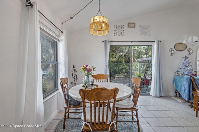 dining area featuring light tile patterned flooring and lofted ceiling