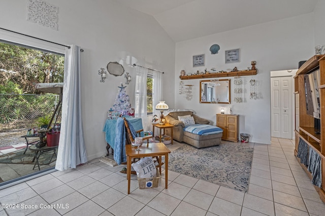 sitting room with light tile patterned floors and high vaulted ceiling