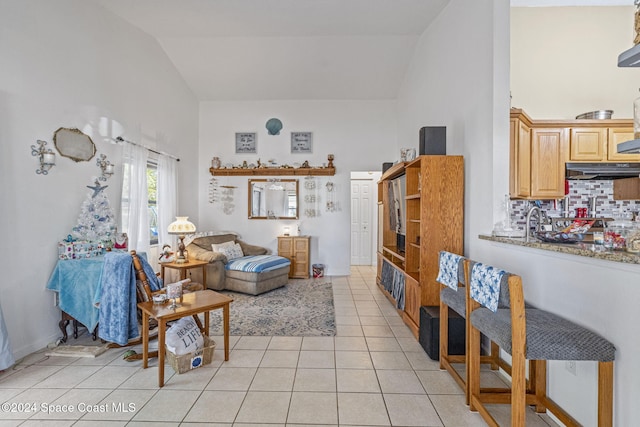 living room featuring light tile patterned floors and high vaulted ceiling