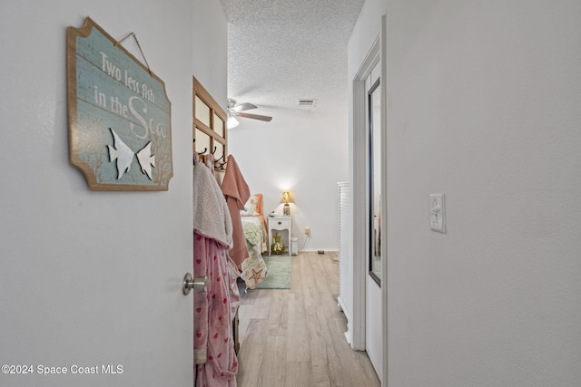 hallway featuring a textured ceiling and light wood-type flooring