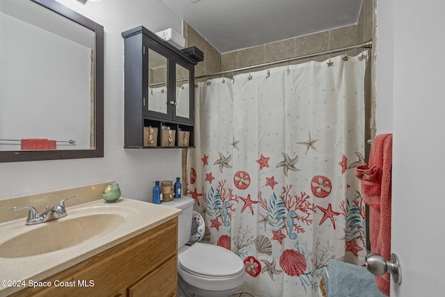 bathroom featuring vanity, curtained shower, and toilet