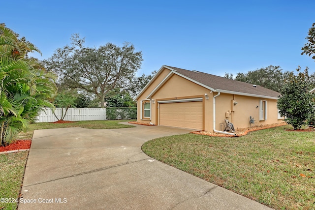 view of side of home featuring a lawn and a garage