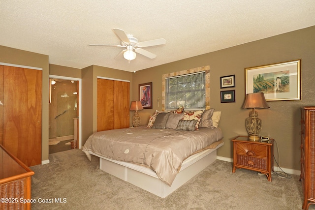 bedroom with ceiling fan, light colored carpet, ensuite bathroom, and a textured ceiling