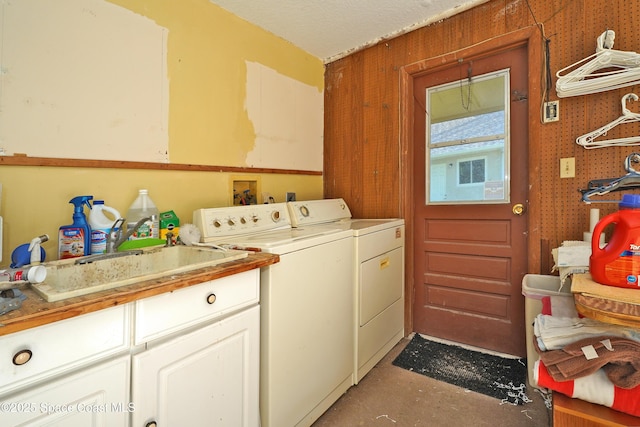 laundry area with sink, washing machine and clothes dryer, and cabinets