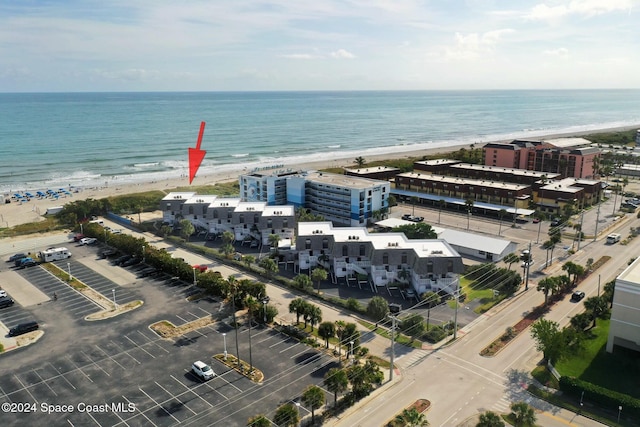 birds eye view of property featuring a water view and a beach view