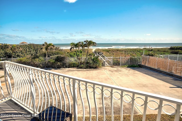 balcony with a water view and a view of the beach