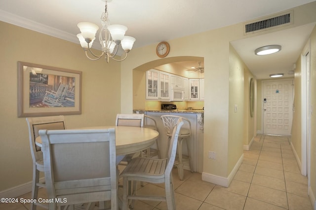 dining room with ceiling fan with notable chandelier, light tile patterned flooring, and crown molding