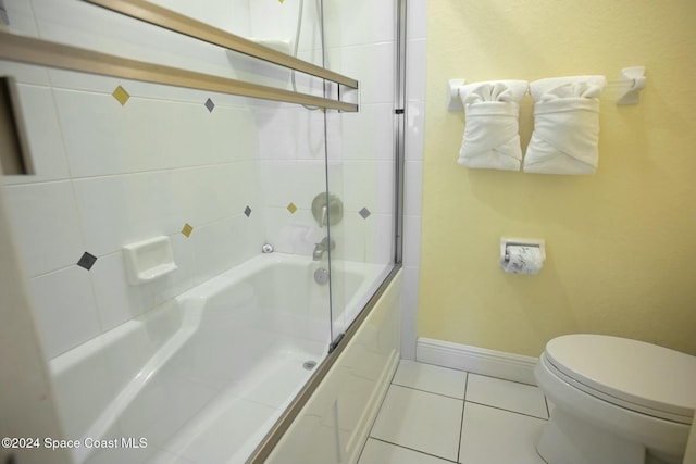 bathroom with tile patterned floors, toilet, and enclosed tub / shower combo