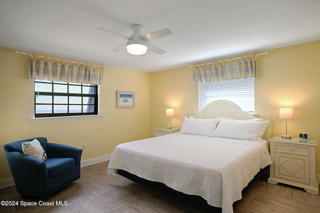 bedroom featuring parquet flooring, multiple windows, and ceiling fan