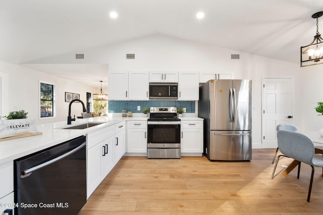 kitchen featuring pendant lighting, sink, light wood-type flooring, white cabinetry, and stainless steel appliances