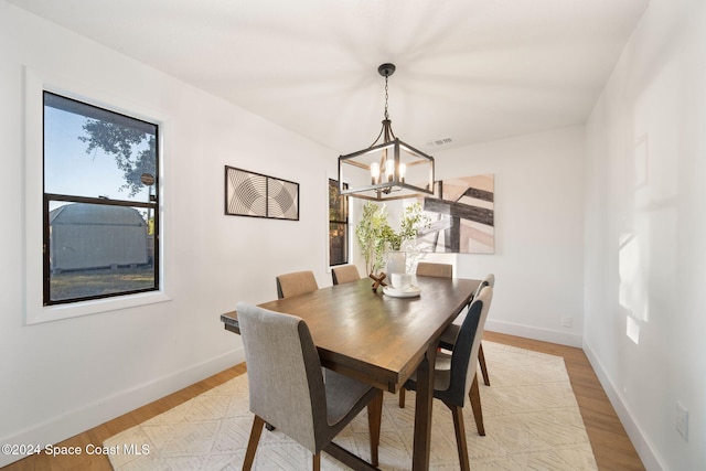 dining space featuring light hardwood / wood-style flooring and a notable chandelier