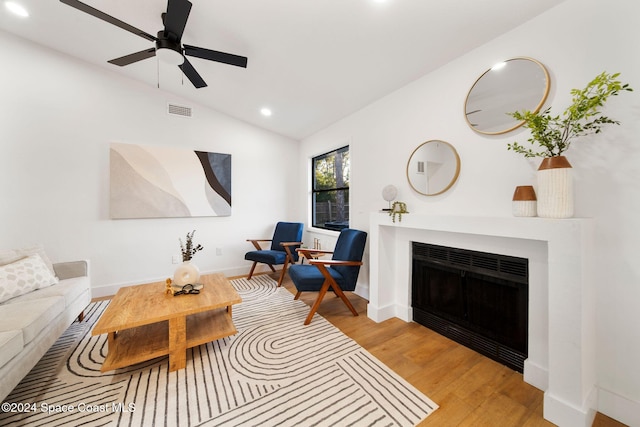 living room with light wood-type flooring, vaulted ceiling, and ceiling fan